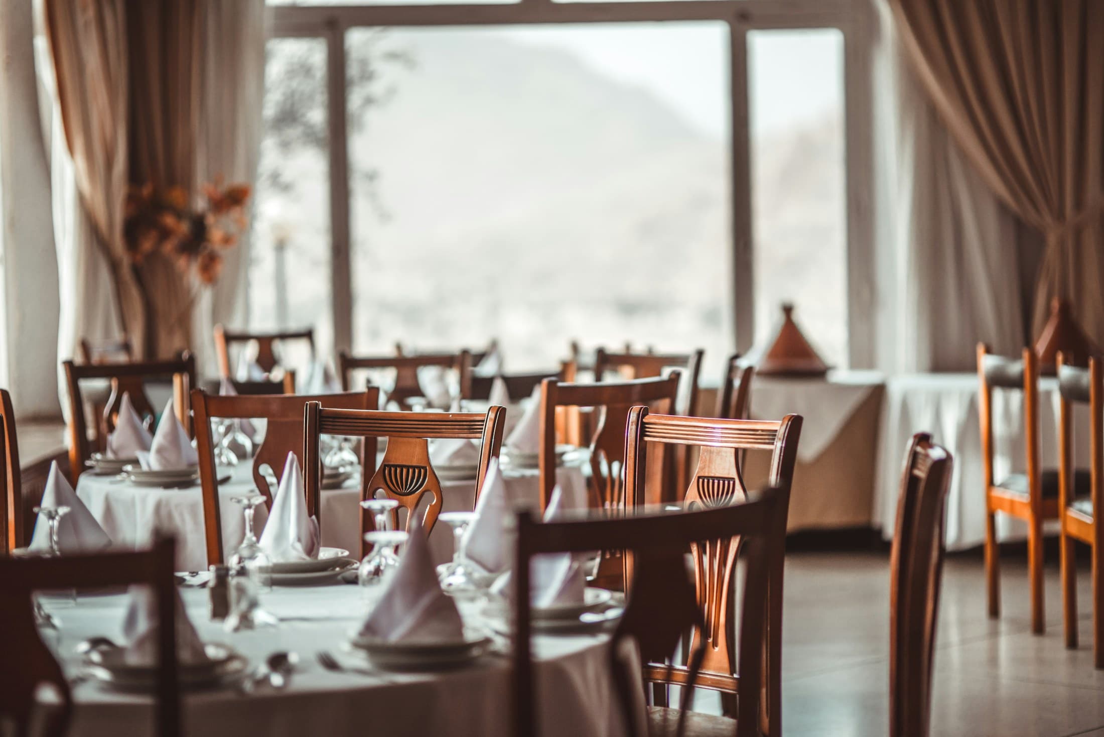 Rows of tables dressed in white linen with folded napkins.