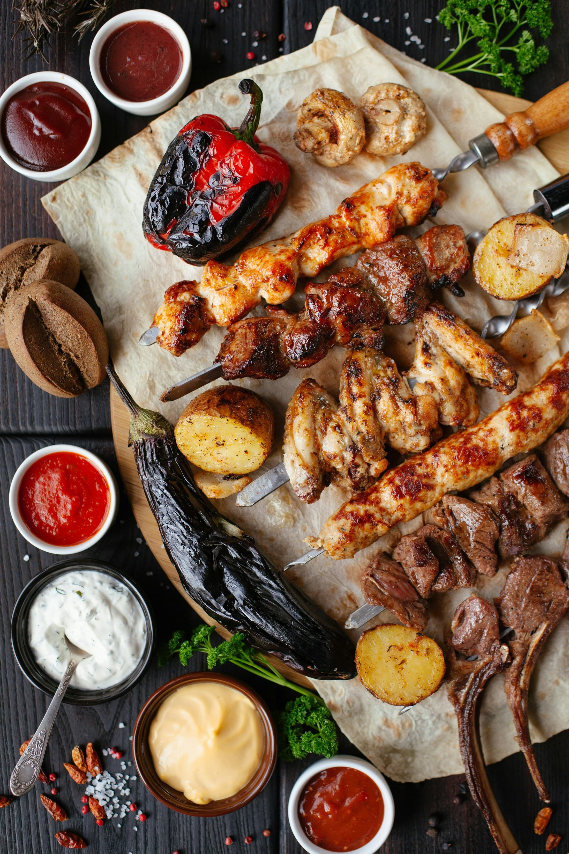 A mixed grill of kebabs, chicken wings, grilled aubergine and dips.