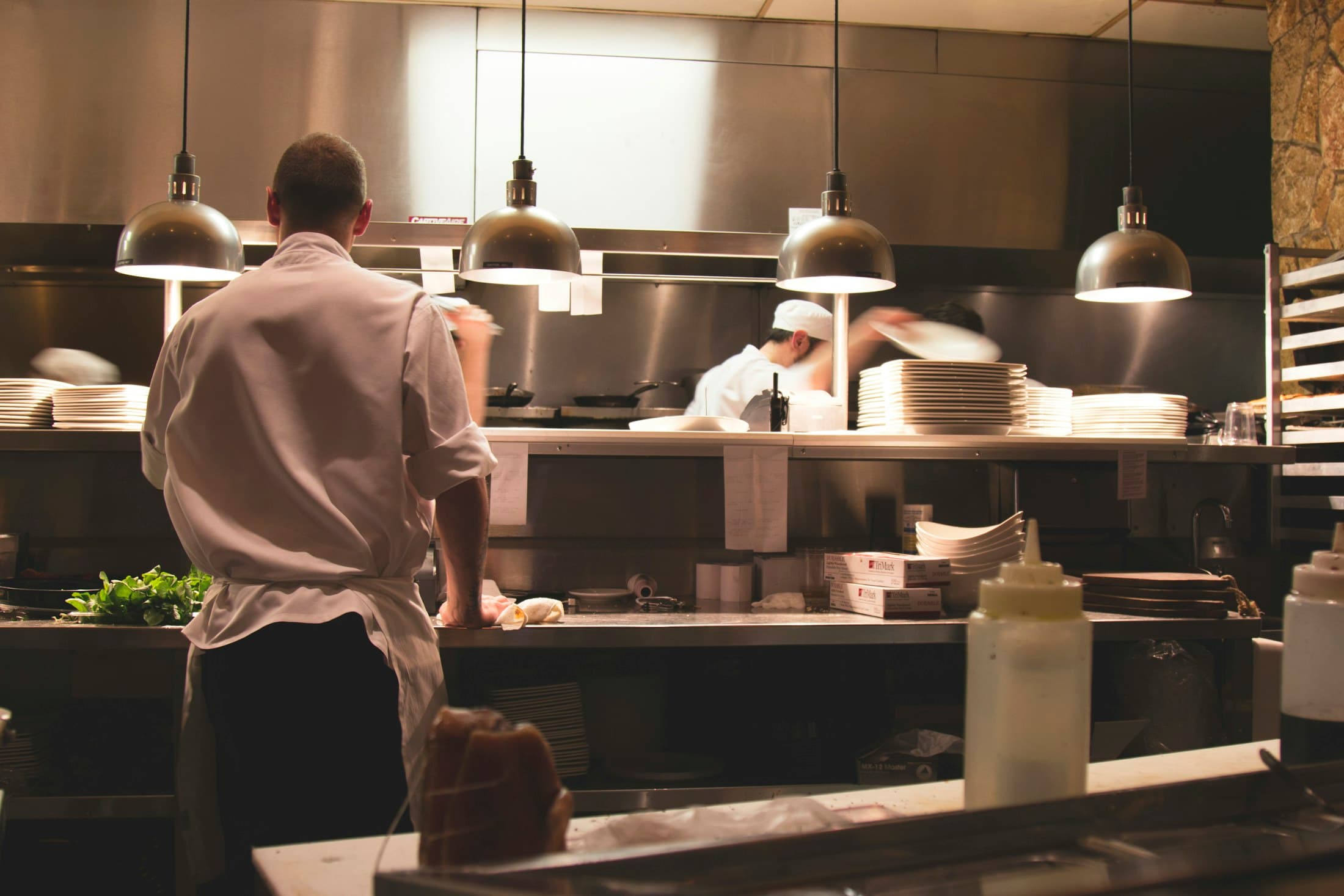 The kitchen line under hanging lamps during service.
