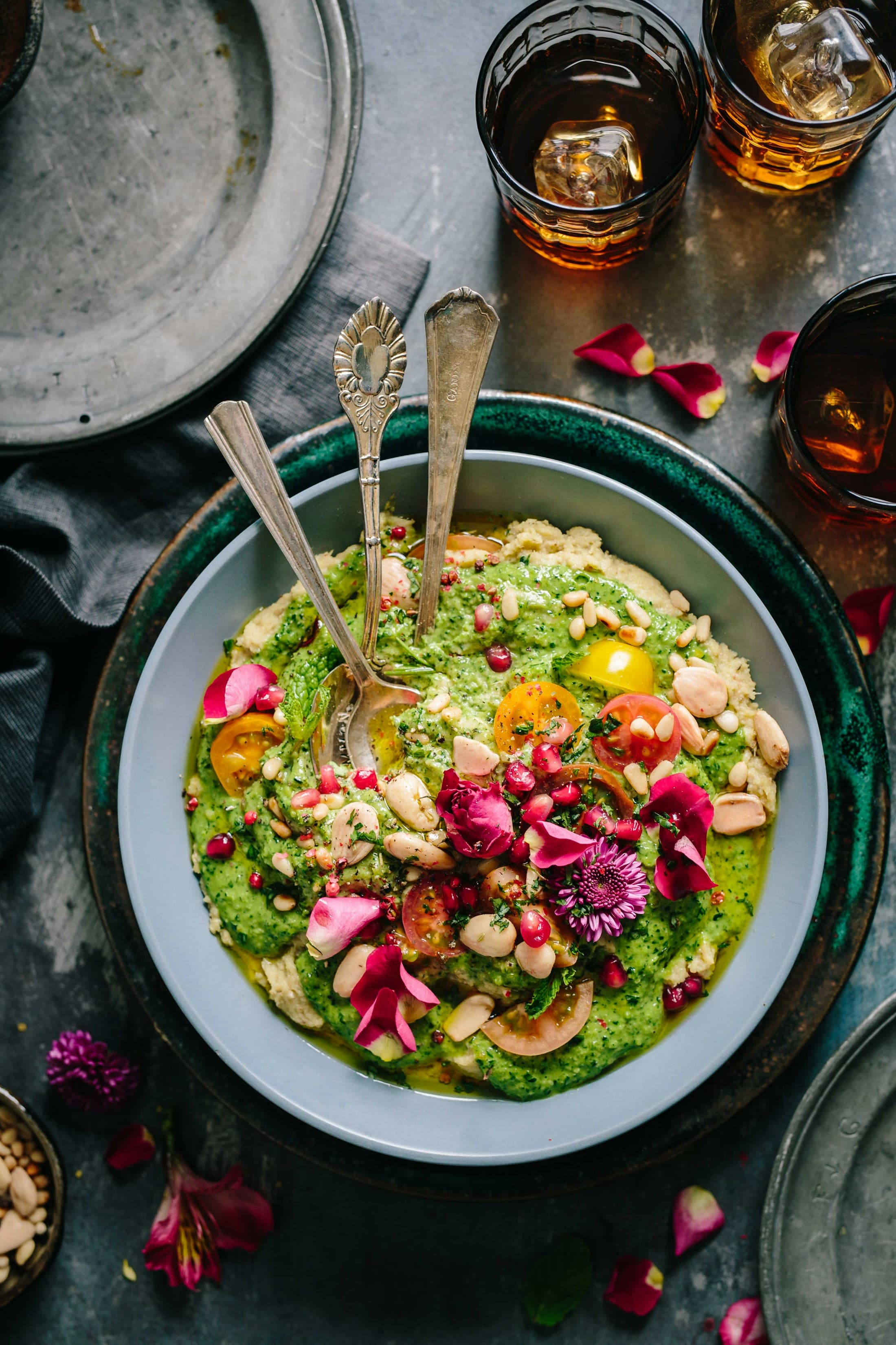 A bowl of herbed grains with tomatoes, beans and edible flowers.