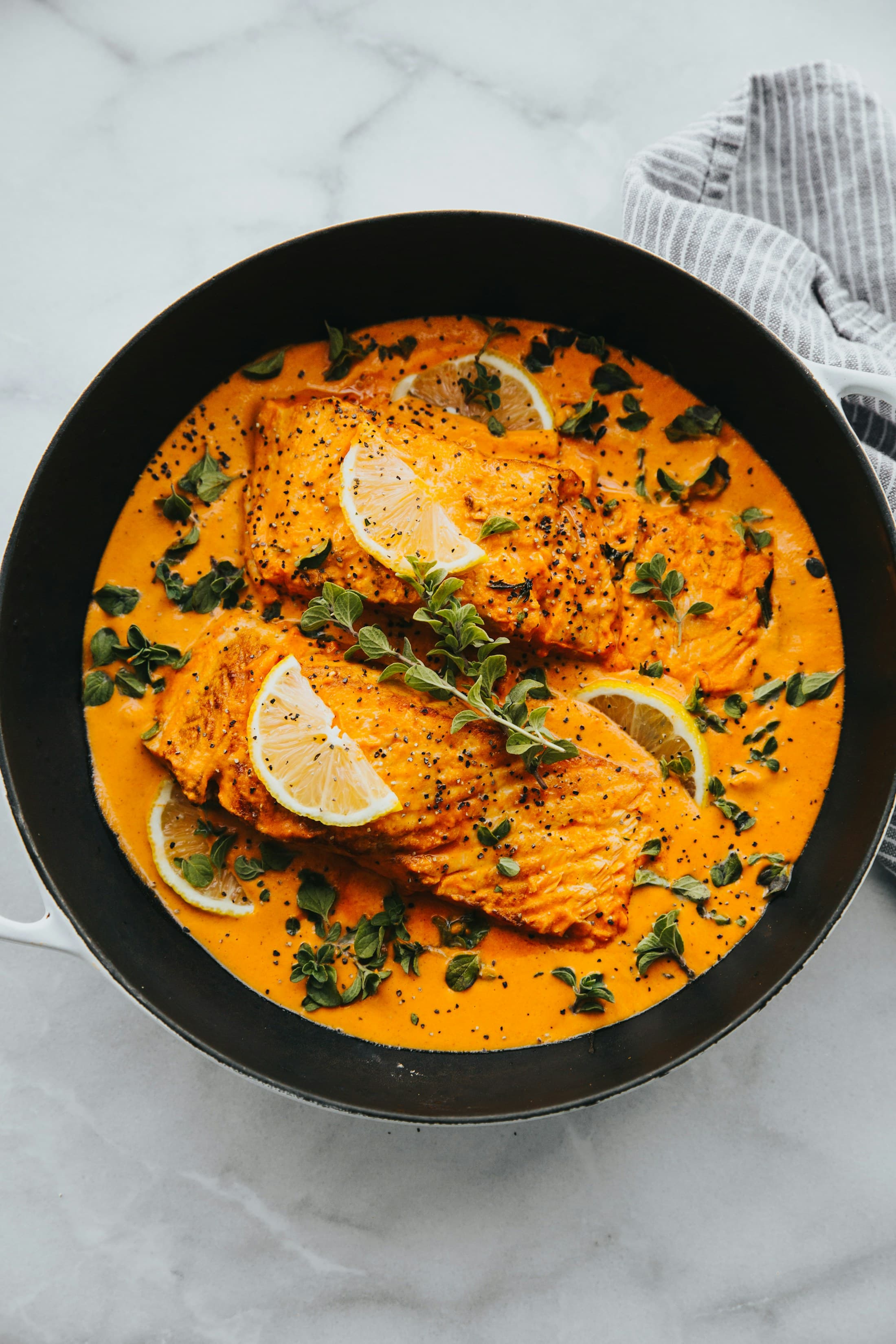 Salmon fillets in a saffron sauce with lemon slices.
