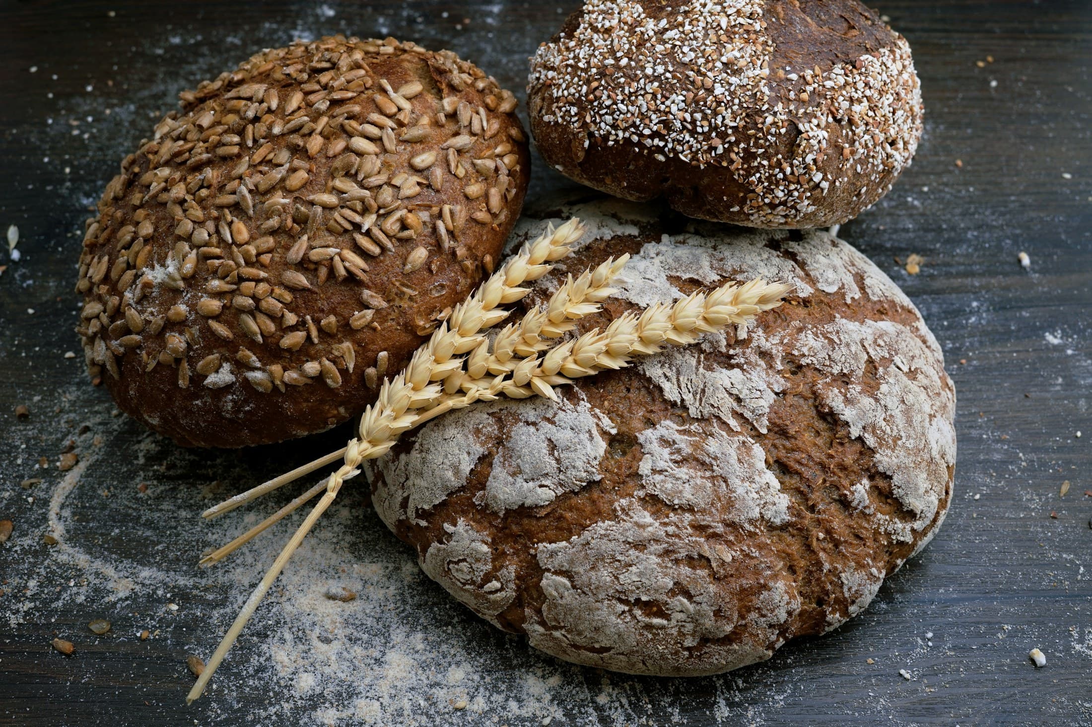 Round loaves of seeded bread with ears of wheat.